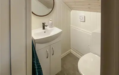 a bathroom with a sink and a toilet and a mirror at Nice Home In Rauland With House A Mountain View in Rauland