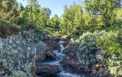 a river with rocks and trees on a hill at Nice Home In Rauland With House A Mountain View in Rauland
