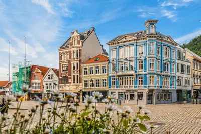 a group of buildings on a street with flowers at Dinbnb Apartments I New 2023 I 600m to Bryggen in Bergen