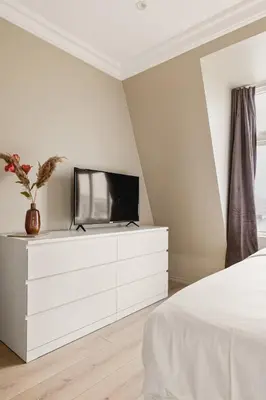 a bedroom with a white dresser with a tv on it at Dinbnb Apartments I New 2021 I SONOS and SMART TV in Bergen