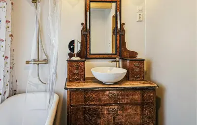 a bathroom with a sink and a mirror on a dresser at 3 Bedroom Lovely Home In Mosvik in Mosvik