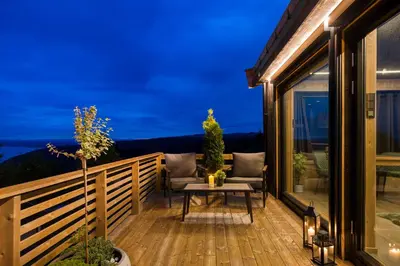 a deck with a table and a couch on it at Hide Hut - Amazing view 50 min from Oslo in Stange