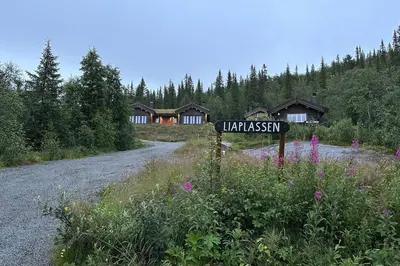 a street sign in the middle of a road with houses at Liaplassen Mountain Chalet - Beitostølen in Beitostøl