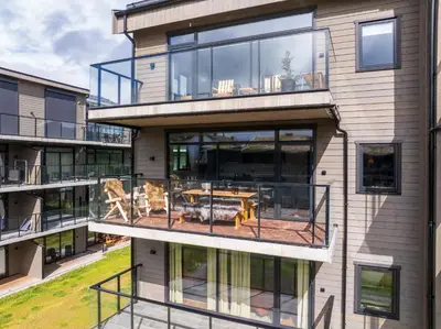 an apartment building with a balcony with a table at Spacious and modern apartment in the heart of Geilo, perfect year round! in Geilo