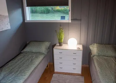a bedroom with two beds and a lamp on a dresser at Apartment-A near Etne-Odda in Etnesjøen