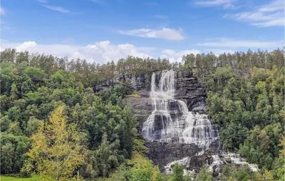a waterfall in the middle of a forest at 3 Bedroom Stunning Home In Vossestrand in Vossestrand