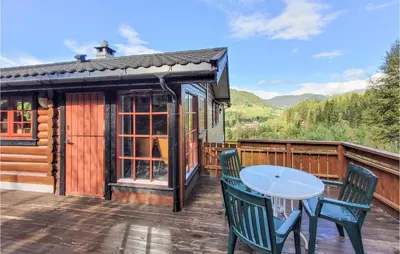 a cabin with a table and chairs on a deck at 3 Bedroom Stunning Home In Vossestrand in Vossestrand