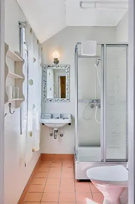 a bathroom with a shower and a sink and a toilet at Visnes Hotel Stryn in Stryn