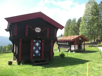 a small house and a smallshed in a field at Åsgardane Gjestegard in Gol