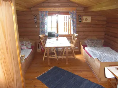 a dining room with a table and benches in a log cabin at Åsgardane Gjestegard in Gol