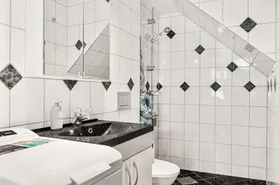 a white bathroom with a sink and a toilet at Dinbnb Apartments I Historical Two-Floor Apartment with Rooftop Panorama I 1645 Heritage in Bergen