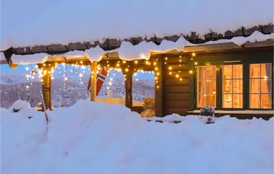 a house covered in snow with christmas lights at Lovely Home In Veggli With Kitchen in Veggli