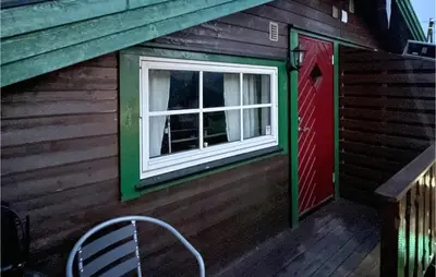 a red door and a window on the side of a house at Lovely Apartment In Trysil With Wifi in Trysil