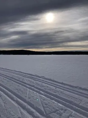 a snow covered field with the sun in the sky at Skomakerhuset in Løten