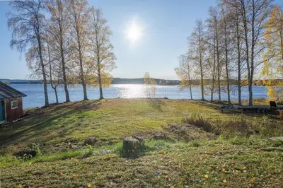 a view of a lake with trees and a house at Skomakerhuset in Løten