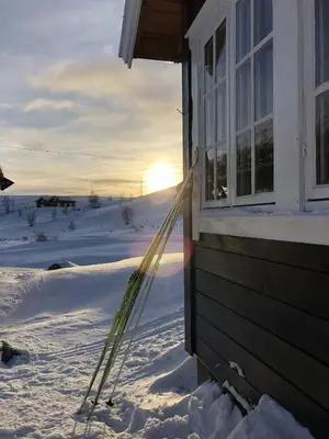 a pair of skis leaning against a house in the snow at Osetunet, small and charming cabin at Ustaoset in Ustaoset