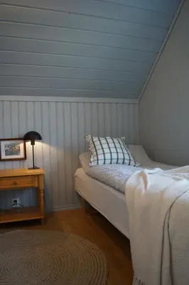 a bedroom with a bed and a table with a lamp at Waterfront Rorbu - By the Beach in Bud
