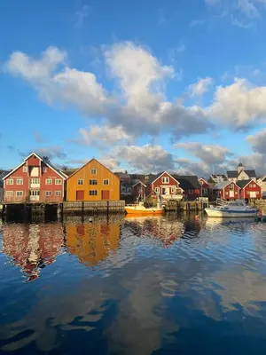a group of houses and boats on a body of water at Waterfront Rorbu - By the Beach in Bud