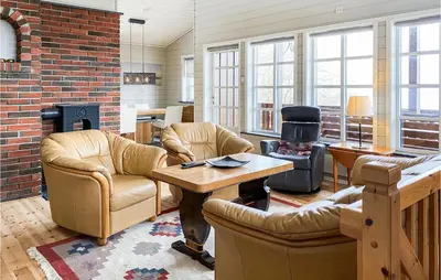a living room with leather furniture and a brick wall at 4 Bedroom Nice Home In Midsund in Midsund