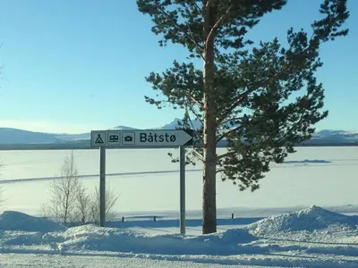 a street sign in the snow next to a tree at Båtstø Camping in Elga