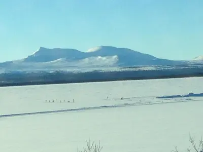 a snow covered field with mountains in the background at Båtstø Camping in Elga