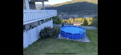 a blue gazebo on the side of a house at Leilighet for korttidsleie in Otta