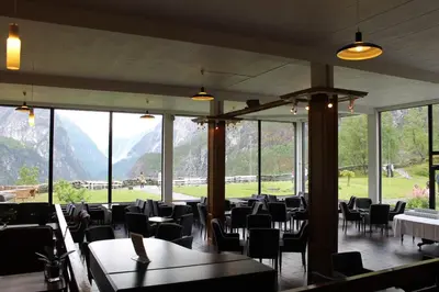 a dining room with tables and chairs and windows at Stalheim Hotel in Stalheim