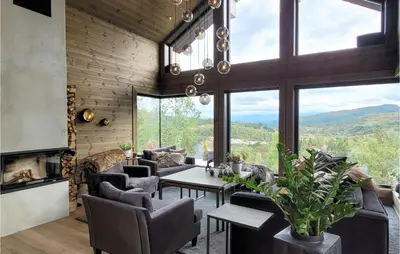 a living room with a table and chairs and a fireplace at Awesome Home In Norheimsund With Sauna in Norheimsund