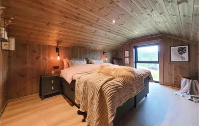 a bedroom with a large bed in a wooden ceiling at Awesome Home In Norheimsund With Sauna in Norheimsund