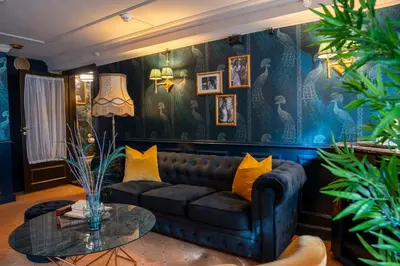 a living room with a couch and a table at Charmante Skostredet Hôtel in Bergen