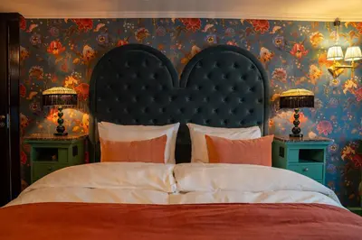 a bedroom with a large bed with two night stands at Charmante Skostredet Hôtel in Bergen