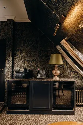 a room with a table and a lamp on a wall at Charmante Skostredet Hôtel in Bergen