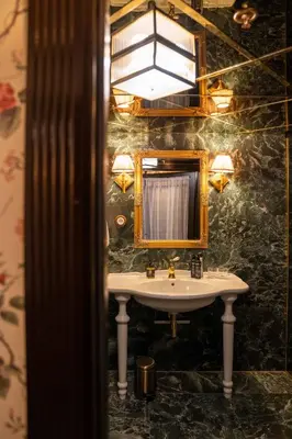 a bathroom with a sink and a mirror at Charmante Skostredet Hôtel in Bergen