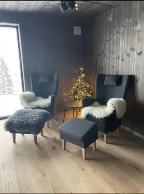 a living room with two chairs and a christmas tree at Ny leilighet på Norefjell - ski in/out in Noresund