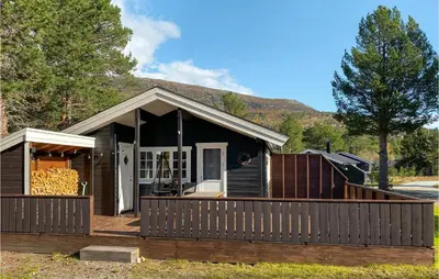 a black house with a fence in front of it at 3 Bedroom Awesome Home In Bjorli in Bjorli