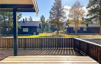 a wooden deck with a house in the background at 3 Bedroom Awesome Home In Bjorli in Bjorli