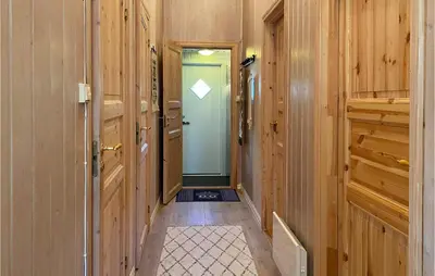 a hallway with wooden walls and a blue door at 3 Bedroom Awesome Home In Bjorli in Bjorli