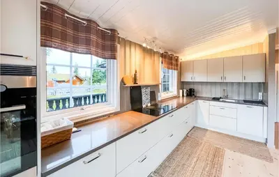 a kitchen with white cabinets and a large window at Beautiful Home In Sjusjøen With Kitchen in Sjusjøen