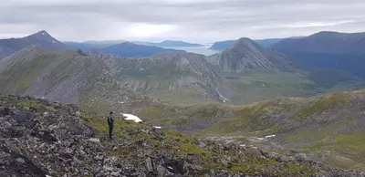 a person standing on the side of a mountain at Apartment, Rekkedal Gjestegard - Sæbø in Ørsta
