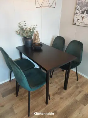 a dining room table with four green chairs at Hafjell Alpinlandsby Apt 88 in Hafjell