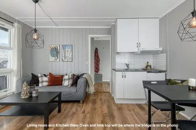 a living room and kitchen with a couch and a table at Hafjell Alpinlandsby Apt 88 in Hafjell