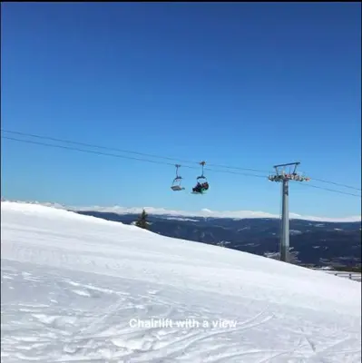 a person riding a ski lift on a snow covered slope at Hafjell Alpinlandsby Apt 88 in Hafjell