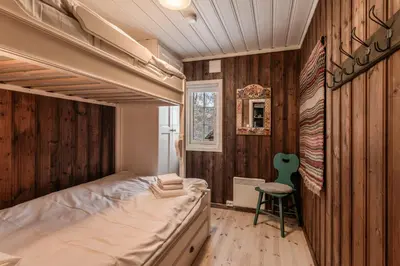 a bedroom with a bed and a chair in it at Sunny and beautiful cabin in Geilo in Geilo