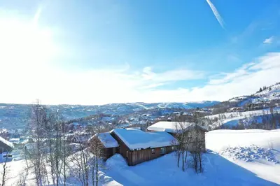 a building covered in snow on top of a mountain at Sunny and beautiful cabin in Geilo in Geilo