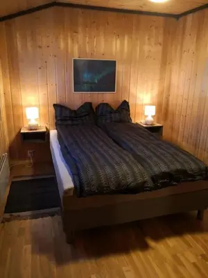a bedroom with a bed with two lamps on two tables at Feriebolig i Garmo in Lom