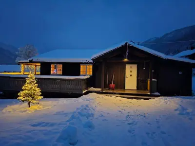 a house with a christmas tree in the snow at Feriebolig i Garmo in Lom