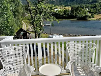 two chairs on a porch with a view of a river at 6 person holiday home in Bjoa-By Traum in Utbjoa