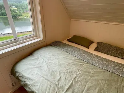 a bed in a small room with a window at 6 person holiday home in Bjoa-By Traum in Utbjoa