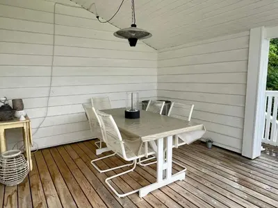 a table and chairs sitting on a porch at 6 person holiday home in Bjoa-By Traum in Utbjoa