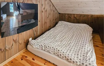 a bedroom with a bed in a room with wooden walls at Awesome Home In Hjartdal With Kitchen in Hjartdal